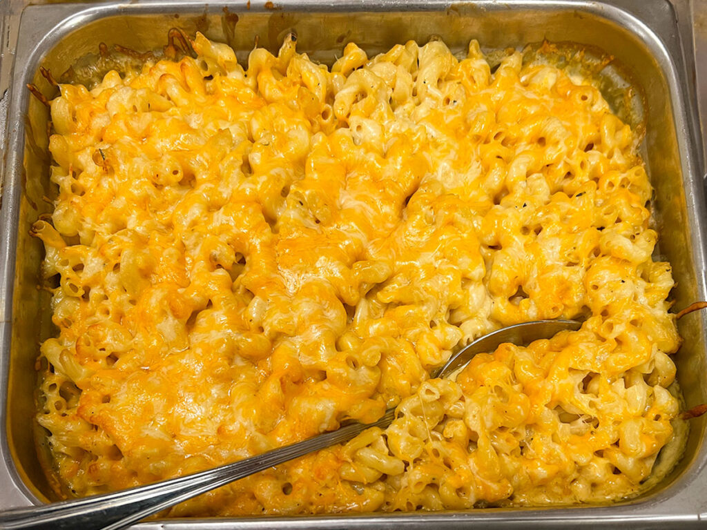 Indulge in a cheesy delight! This metal pan holds a scrumptious mac and cheese dish, made with five different cheeses.