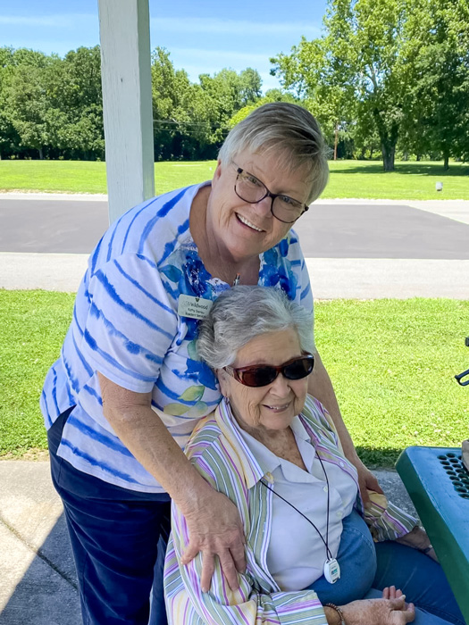 Beautiful day for a picnic in the park! A senior resident and a staff member enjoying the sunny weather together.