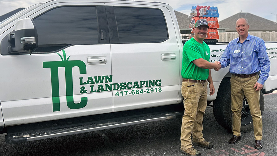 A team member from The Wildwood Senior Living shares a handshake with the owner of TC Lawn and Landscaping on Small Business Day.